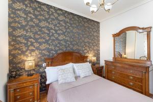 a bedroom with a bed and a dresser and a mirror at La Casona de Sacramenia in Sacramenia