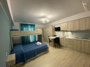 a bedroom with a bed and a kitchen with a desk at La casa dell’Aurora in Falcone