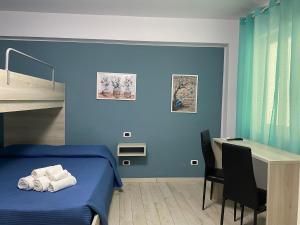 a blue bedroom with a bed and a desk at La casa dell’Aurora in Falcone +22 photos