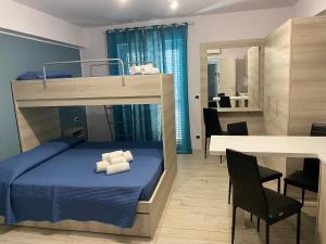 a bedroom with a bunk bed and a dining room at La casa dell’Aurora in Falcone
