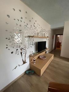 a living room with a tree with birds on the wall at Casa Cadore Grea in Grea