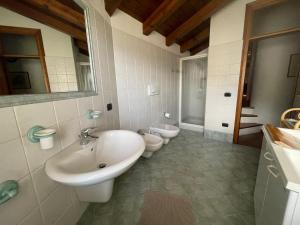 a bathroom with two sinks and a toilet at Casa Cadore Grea in Grea +16 photos