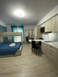 a bedroom with a bed and a kitchen with a table at La casa dell’Aurora in Falcone