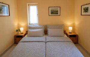 a bedroom with a bed with pillows and a window at Margaréta Apartman in Balatonudvari