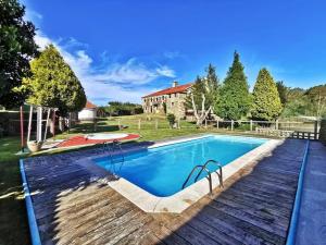 a swimming pool in front of a house at Hotel Pazo Do Souto in Carballo