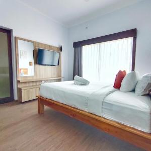 a bedroom with a large bed with a large window at Canggu Rice Field Villa 8B in Dalung