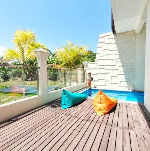 an orange and blue umbrella sitting on a wooden deck at Canggu Rice Field Villa 8B in Dalung