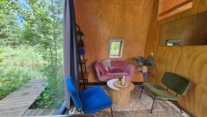a screened in porch with a chair and a table at Tiny house De Wylp in Westergeest