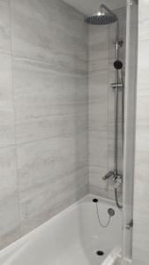 a white bath tub with a shower in a bathroom at Edifício Panorâmico - Falésia de Sesimbra in Sesimbra