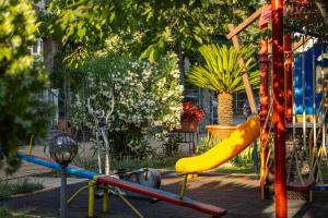 a playground with a yellow slide in a park at Hotel Central in Sunny Beach