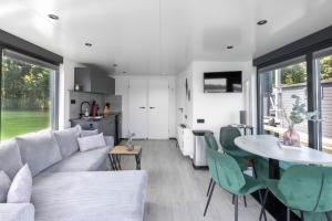 a living room with a couch and a table at Houseboat Marina Mookerplas on the Water | 4 - 6 people in Middelaar +30 photos