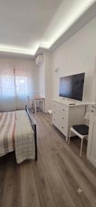 a bedroom with a bed and a dresser with a flat screen tv at Alloggio per uso Turistico Capone Alessia - A DUE PASSI DAL CENTRO in Viterbo