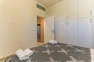 ein Schlafzimmer mit Bett, weißen Schränken und Handtüchern in der Unterkunft Papiro Apart Hotel in Byblos + 259 Fotos