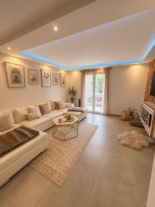 a living room with a couch and a table at Maison de charme avec Jacuzzi privé in Sarcelles