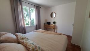 a bedroom with a bed with a window and a pillow at La Villa Blateiras in Générargues