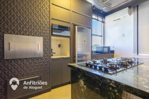 a kitchen with a counter with a stove at Cobertura Duplex Vista Cidade Centro TV4061 in Blumenau