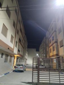a car parked in a parking lot between two buildings at Apprtmnt jury de luxe 6 in Nador