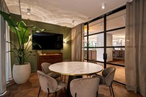 a dining room with a table and chairs and a tv at MAXX by Steigenberger Vienna in Vienna
