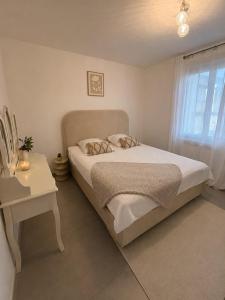 a bedroom with a bed and a table and a window at Maison de charme avec Jacuzzi privé in Sarcelles +11 photos
