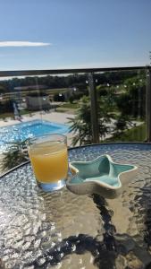 a glass of orange juice sitting on top of a table at Zen Studio Olimp Poolside in Olimp