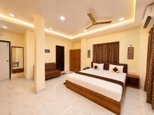 a bedroom with a large bed and a ceiling fan at Hotel Pushparaj Puri - Beach front Hotel near Light House - Sea Facing AC Rooms - with Restaurant, Parking Facilities in Puri