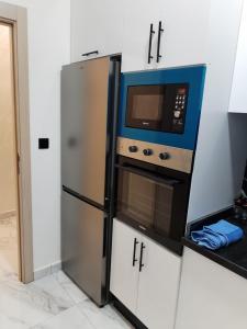 a kitchen with a microwave and a refrigerator at Apprtmnt jury de luxe 6 in Nador