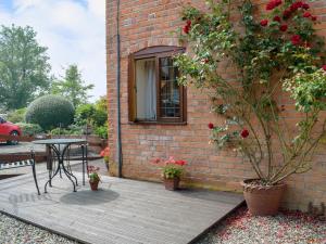a patio with a table and a brick building at Y Bwthyn-Uk31367 in Tregynon