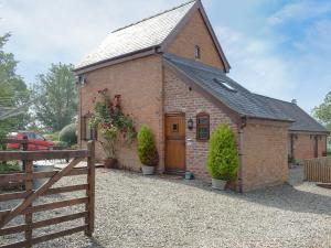 a small brick building with a wooden door at Y Bwthyn-Uk31367 in Tregynon