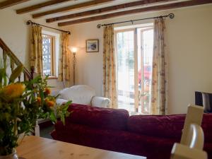 a living room with a red couch and a window at Y Bwthyn-Uk31367 in Tregynon