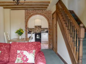 a living room with a red couch and a staircase at Y Bwthyn-Uk31367 in Tregynon +5 photos