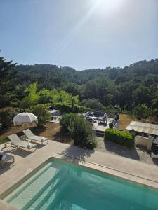 a swimming pool with chairs and umbrellas at La Villa Blateiras in Générargues