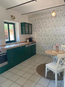 a kitchen with green cabinets and a table at Smeers Hof in Böhme