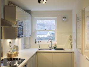a small kitchen with a sink and a window at 12A Elm Court in Keswick