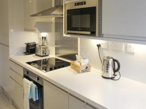 a kitchen with a microwave and a stove top oven at 12A Elm Court in Keswick