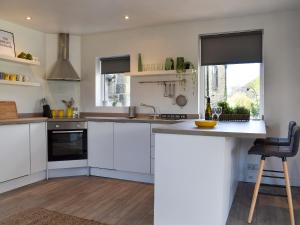 a kitchen with white cabinets and a counter top at Little Plumtree in Addingham