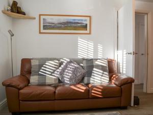a brown leather couch sitting in a living room at Wise Cottage in Keswick