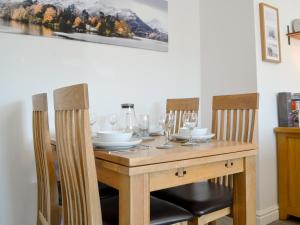 a dining room table with chairs and wine glasses at Wise Cottage in Keswick