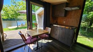 a kitchen and dining room with a table and a window at Tiny house De Ljip in Westergeest