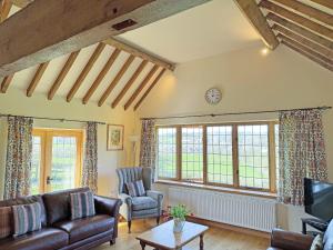 a living room with a couch and chairs and windows at Talog Barn-Uk31366 in Tregynon