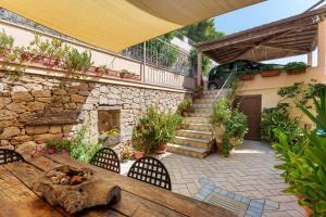 an outdoor patio with a wooden table and chairs at Camera a Dorgali al B&B Sa Madalena in Dorgali