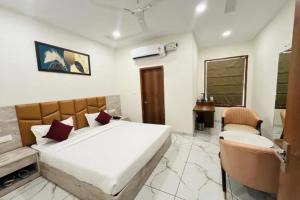 a bedroom with a large bed and two chairs at FabHotel K9 Regency in Zirakpur +29 photos