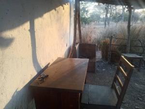 a wooden table and a chair in a shed at Mabuu Drive Inn in Waya