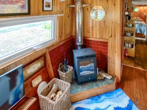 a tiny house with a stove in a room at The Prince - Uk42204 in Clachan of Glendaruel