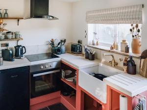 a kitchen with a sink and a stove at The Green One On The End in Thurton