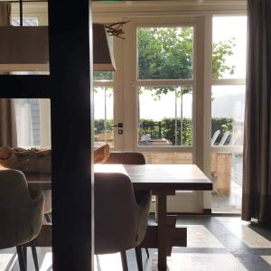 a dining room with a table and some windows at Erve 't Hacht in Ane