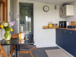 a kitchen with a table with a vase of flowers at Willow's Rest in Crafthole