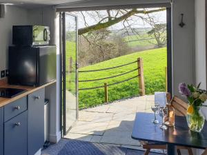 a kitchen with a door open to a patio at Willow's Rest in Crafthole +7 photos