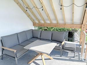 a patio with a couch and a table at Little Knott in High Nibthwaite