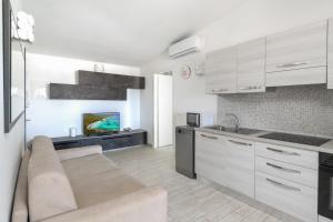 a living room with a couch and a kitchen at NRH Cannigione Sunrise Rooftop in Cannigione +38 photos