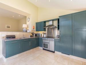 a large kitchen with blue cabinets and appliances at Wellwood - Uk49290 in Preston